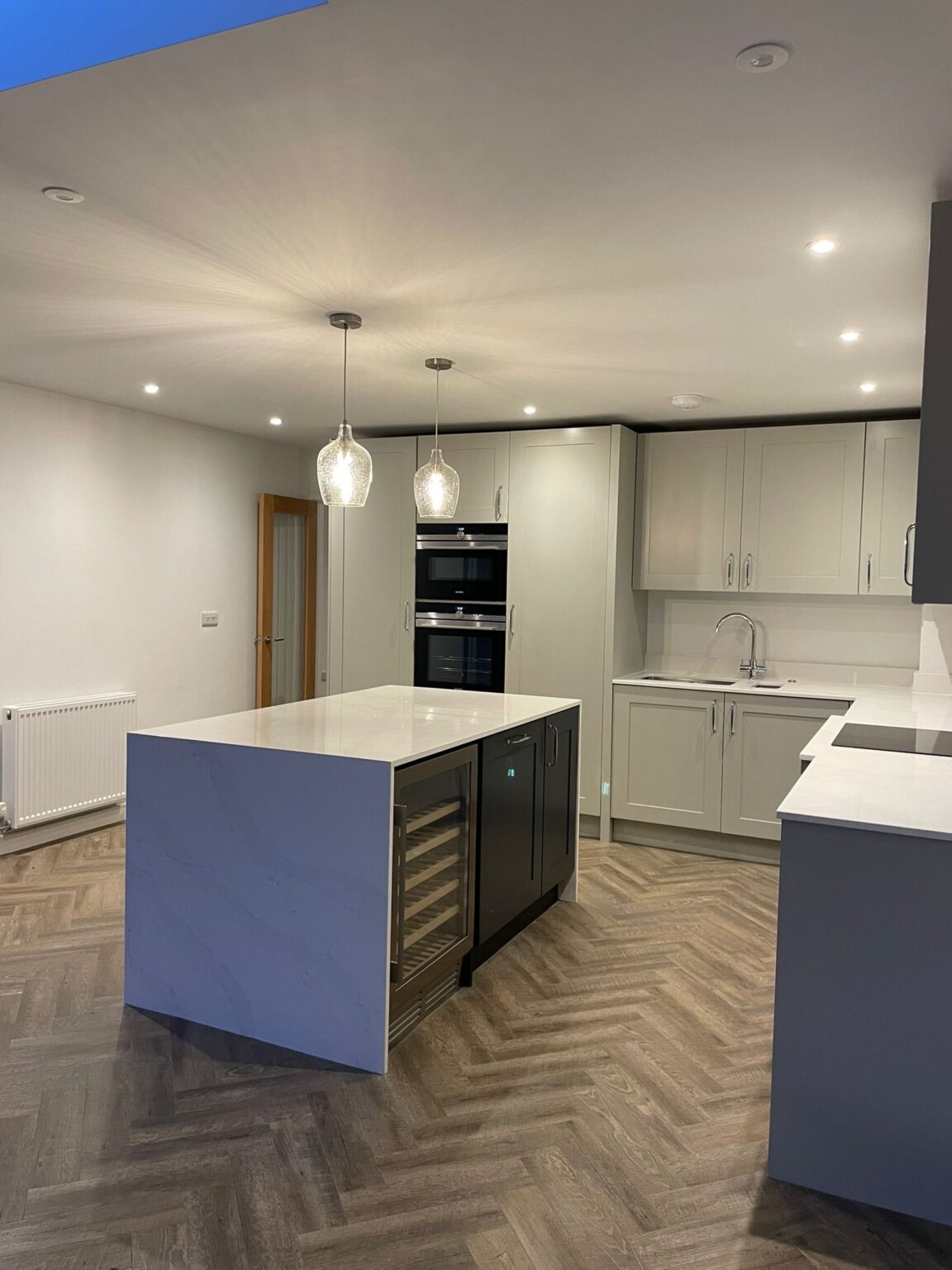 Kitchen inside an extended house in Nuneaton with island and herringbone floor