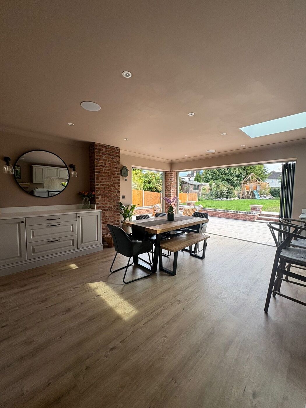 Dining area with feature mirror and exposed-brick detailing