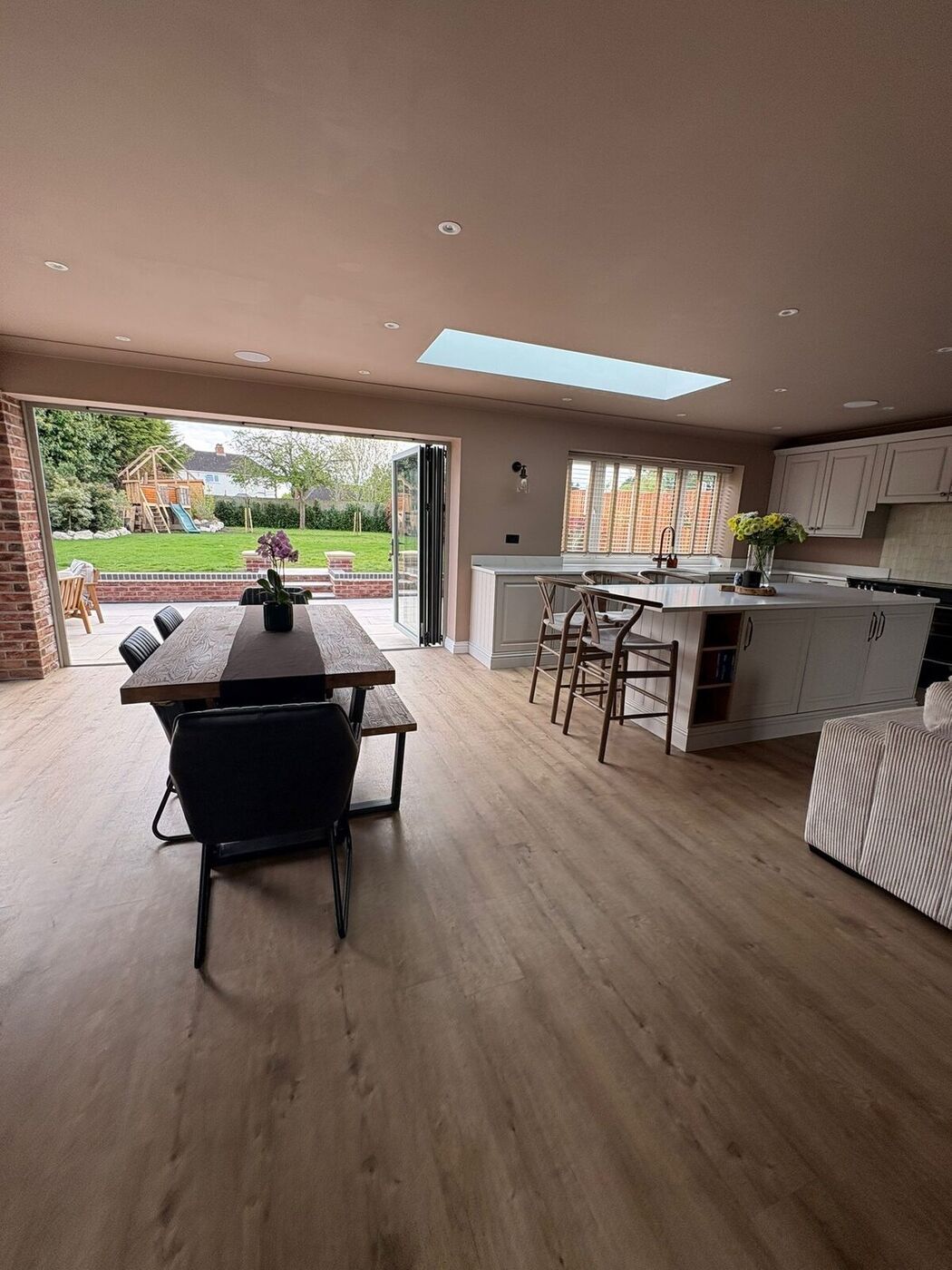 Kitchen island with bifold doors open to the garden